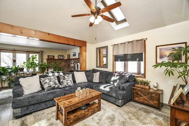 living room with hardwood / wood-style flooring, lofted ceiling with skylight, and ceiling fan