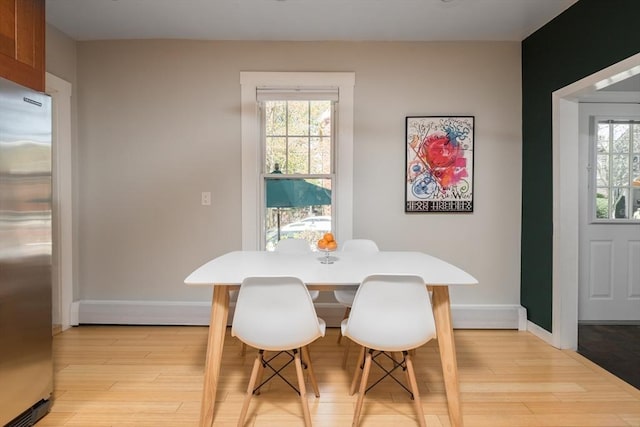 dining area featuring light wood-style floors and baseboards