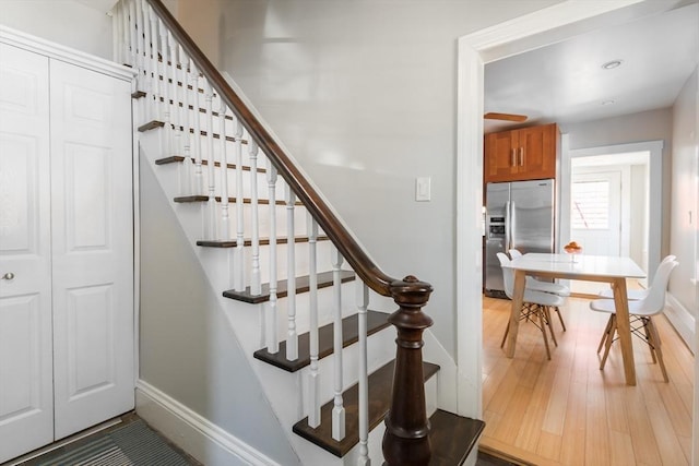stairway featuring baseboards and wood finished floors