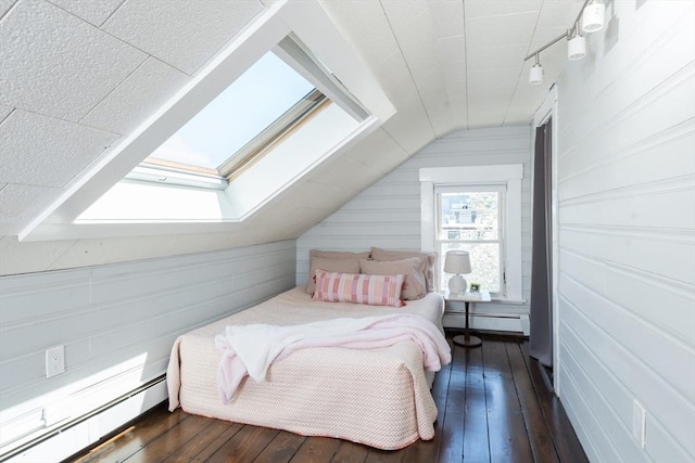 bedroom with a baseboard heating unit, dark wood-style floors, and lofted ceiling with skylight
