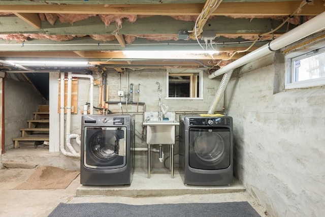 below grade area featuring a sink, stairway, and washer and clothes dryer