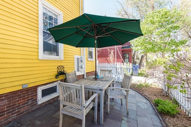 view of patio featuring fence and outdoor dining area