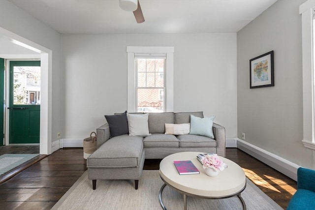 living area with baseboards, ceiling fan, and hardwood / wood-style flooring