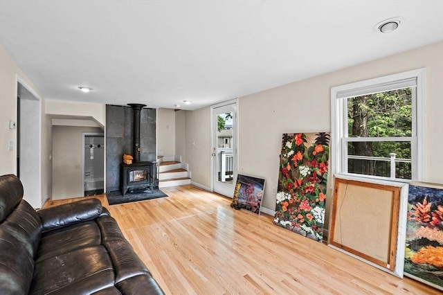 5 Emery Ct, Stoneham, MA 02180 - living area featuring a wood stove, wood finished floors, plenty of natural light, and baseboards
