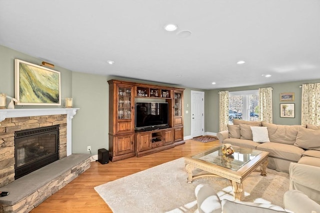 living area featuring recessed lighting, light wood-style floors, and a fireplace