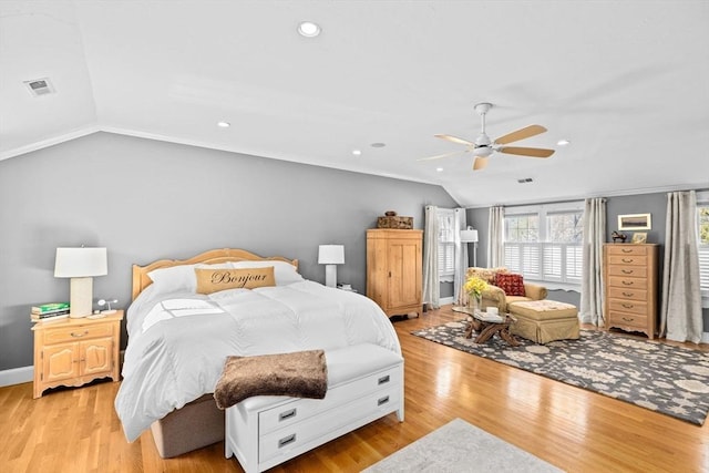 bedroom with vaulted ceiling, visible vents, a ceiling fan, light wood-type flooring, and baseboards