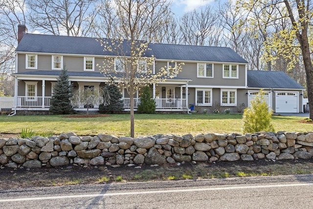 view of front of property featuring a chimney, an attached garage, a front lawn, and covered porch