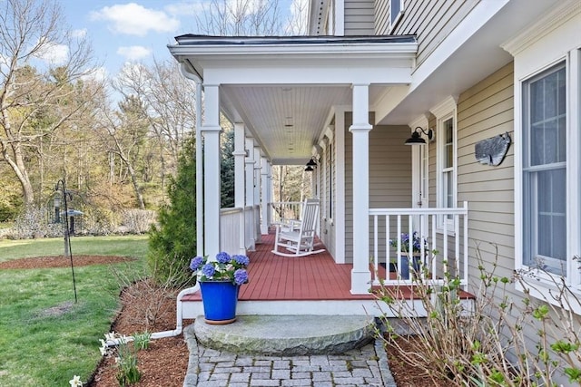 deck featuring covered porch and a yard