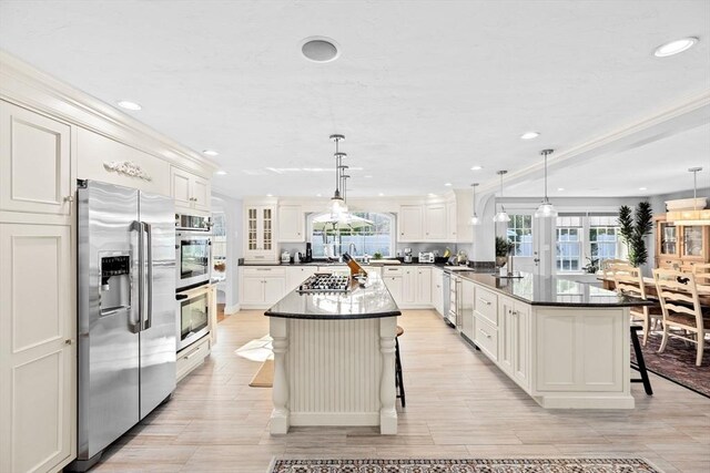 kitchen with a peninsula, a breakfast bar, recessed lighting, and appliances with stainless steel finishes