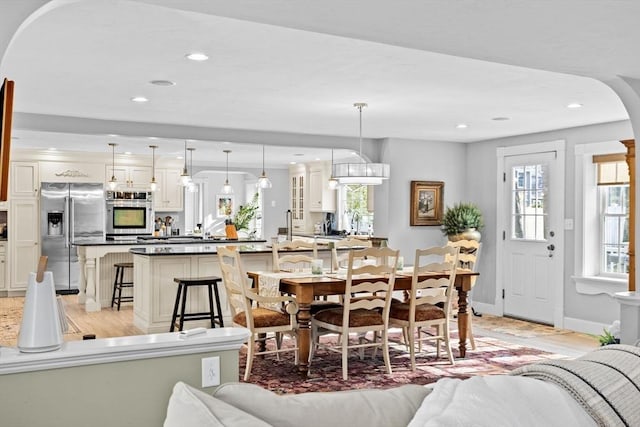 dining space featuring light wood finished floors, baseboards, and recessed lighting