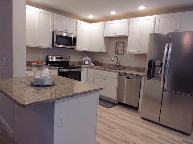 kitchen featuring light stone countertops, appliances with stainless steel finishes, sink, and white cabinets