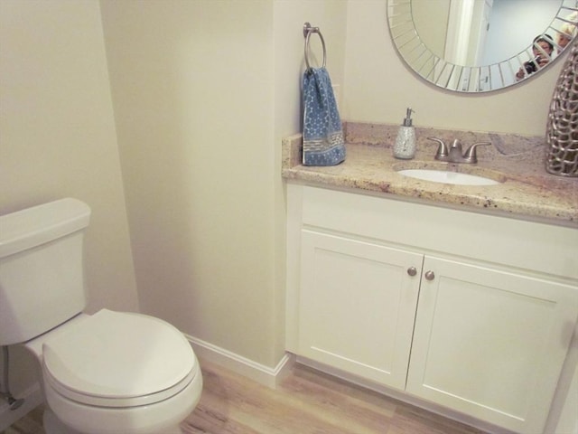 bathroom featuring hardwood / wood-style flooring, vanity, and toilet