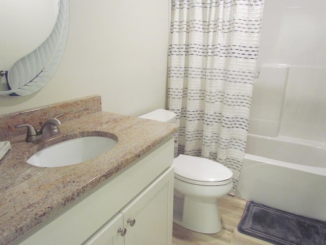 full bathroom with wood-type flooring, toilet, shower / bathtub combination with curtain, and vanity