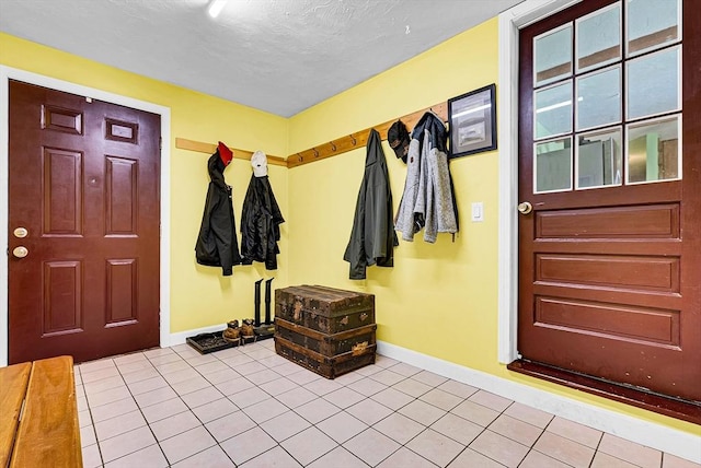 mudroom featuring a textured ceiling, baseboards, and tile patterned floors