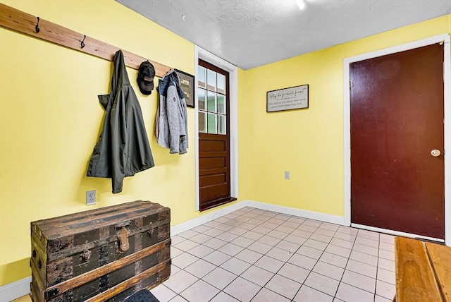 interior space featuring baseboards, a textured ceiling, and tile patterned floors