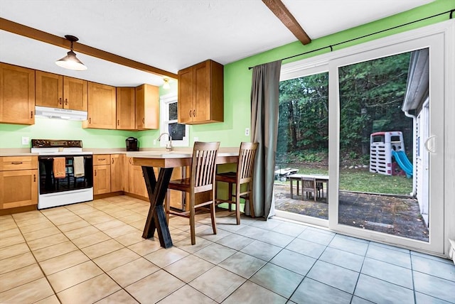 kitchen with light tile patterned floors, under cabinet range hood, electric stove, light countertops, and beam ceiling