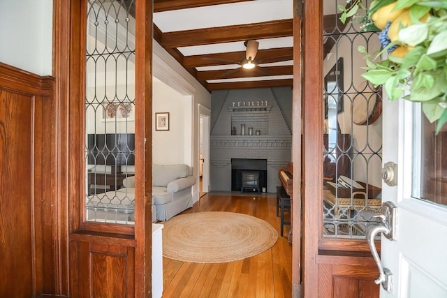 living room featuring hardwood / wood-style flooring, ceiling fan, and beam ceiling