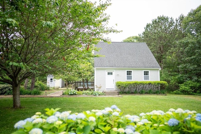 10 Kellies Path, Eastham, MA 02642 - view of front facade with a shed, a front yard, and roof with shingles