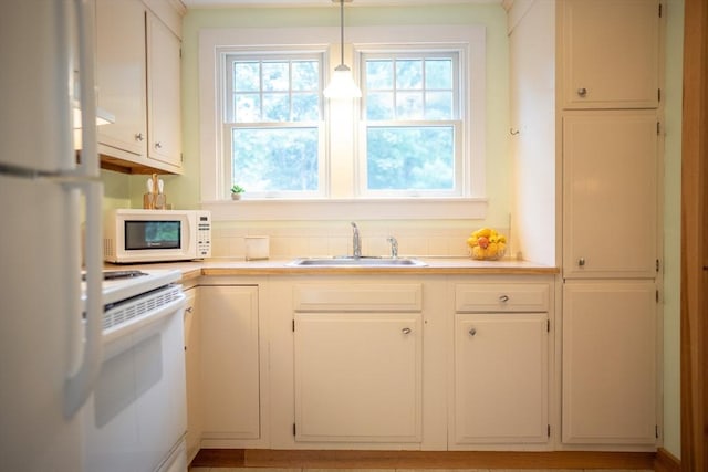 10 Kellies Path, Eastham, MA 02642 - kitchen with white appliances, healthy amount of natural light, light countertops, and decorative light fixtures