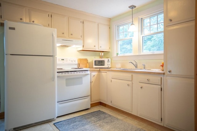 10 Kellies Path, Eastham, MA 02642 - kitchen with white appliances, under cabinet range hood, light countertops, hanging light fixtures, and light tile patterned floors