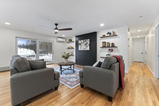 living area with recessed lighting, a wall unit AC, light wood-style flooring, and baseboards