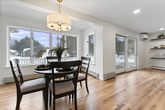 dining area with a wall mounted AC, light wood-style flooring, and baseboards