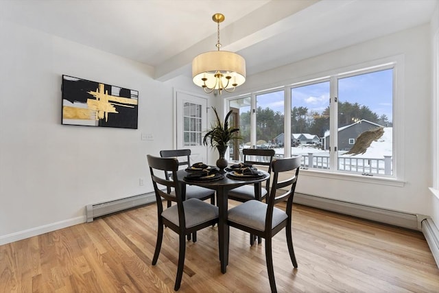 dining space featuring a baseboard heating unit, a chandelier, light wood-style flooring, and baseboards