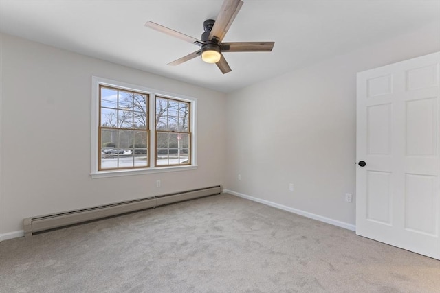 spare room featuring a baseboard heating unit, carpet, ceiling fan, and baseboards