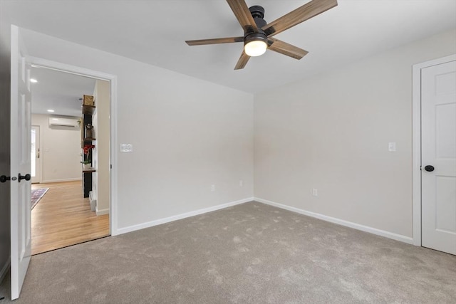 unfurnished room with carpet floors, a wall mounted air conditioner, and baseboards