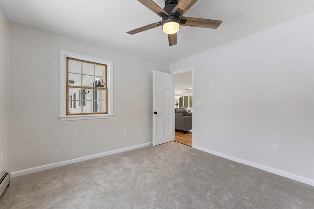 carpeted empty room with baseboards, a baseboard heating unit, and a ceiling fan