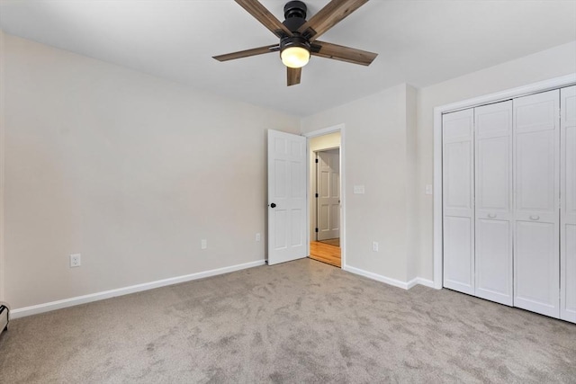 unfurnished bedroom with baseboards, a baseboard radiator, ceiling fan, carpet floors, and a closet