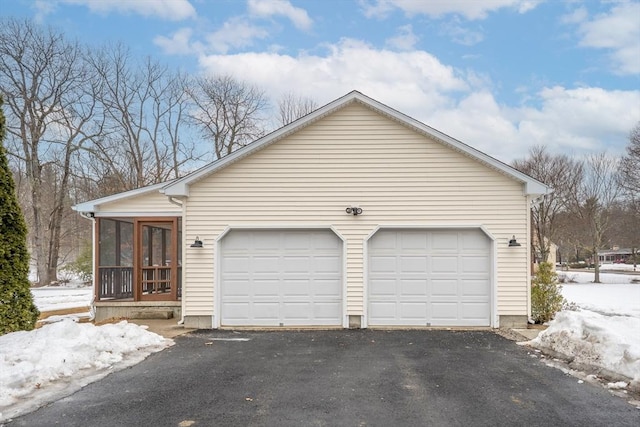 exterior space with a garage, aphalt driveway, and a sunroom