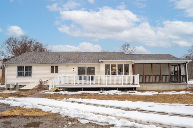 view of front of home with a sunroom and roof with shingles