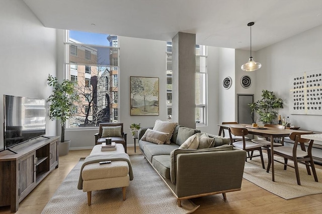 living area with light wood-type flooring and a healthy amount of sunlight