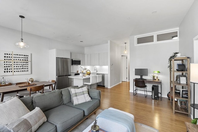 living room with light wood-type flooring and baseboards