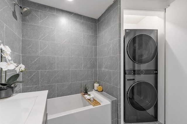 bathroom with a shower, a bathtub, tile walls, and stacked washer and clothes dryer