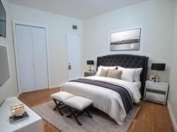 bedroom with a closet, baseboards, and wood finished floors