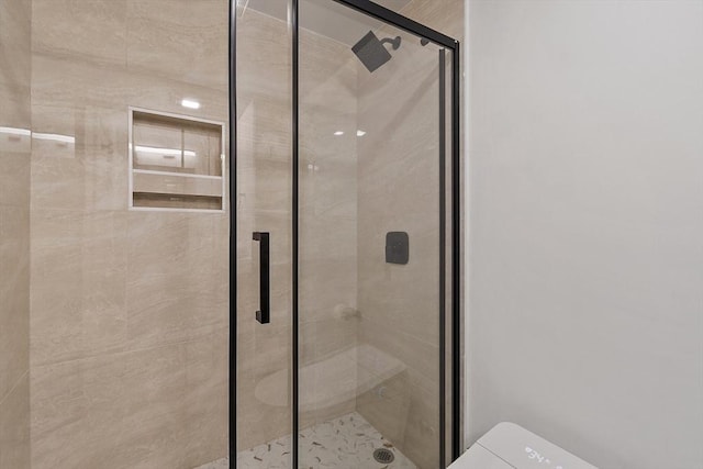 full bathroom featuring toilet and a stall shower