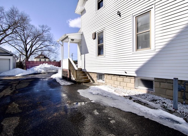 view of snow covered exterior with fence