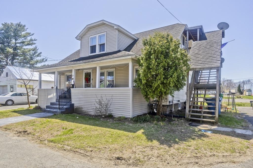 view of front of house with a porch, roof with shingles, stairs, and a front yard