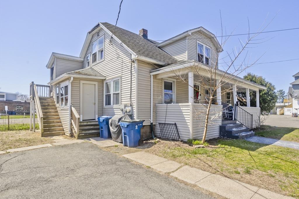 view of front of home featuring roof with shingles, covered porch, a chimney, and stairs