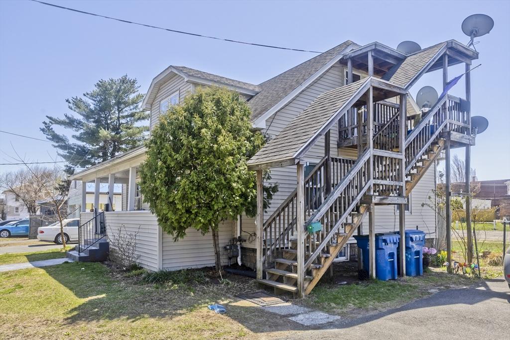 view of property exterior featuring a shingled roof and stairway