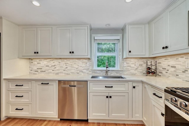 277 Ridgewood Dr, Norwood, MA 02062 - kitchen featuring appliances with stainless steel finishes, tasteful backsplash, white cabinetry, recessed lighting, and light wood-style floors
