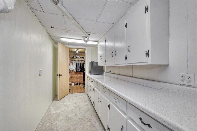 277 Ridgewood Dr, Norwood, MA 02062 - kitchen with a drop ceiling, light colored carpet, light countertops, and white cabinets