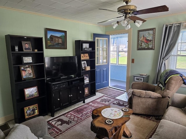living area with crown molding and a ceiling fan