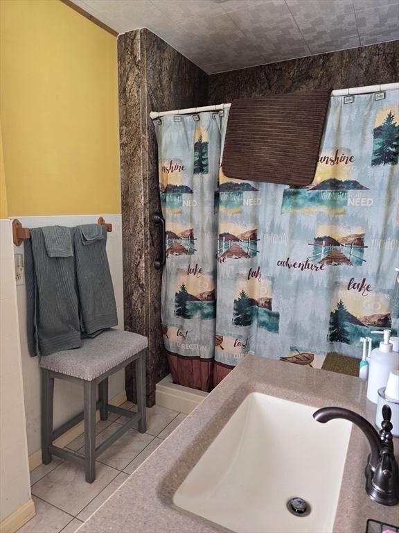 full bathroom featuring tile patterned floors, a sink, and curtained shower