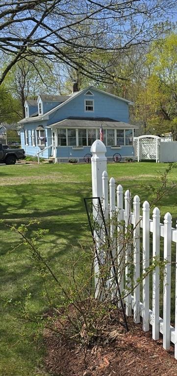 exterior space with a lawn, a chimney, and fence private yard