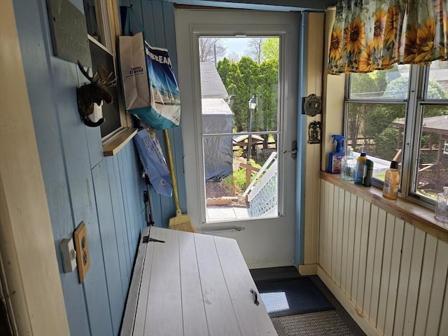 doorway to outside featuring wood walls