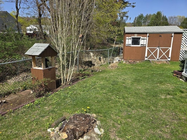 view of yard with an outbuilding, fence, and a storage shed