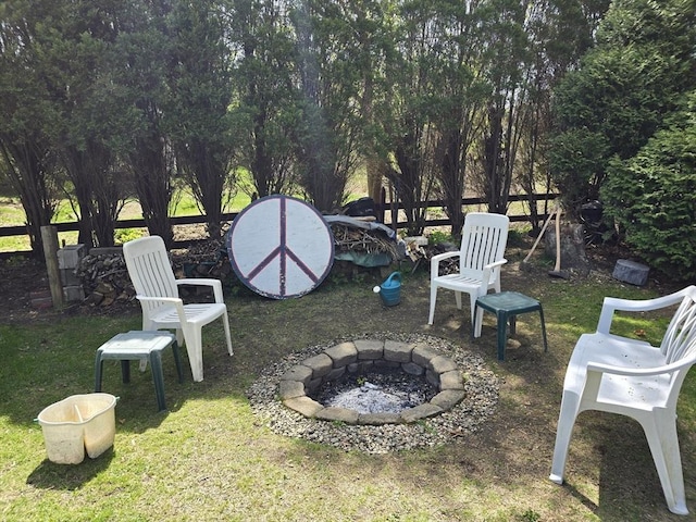 view of yard featuring an outdoor fire pit and fence